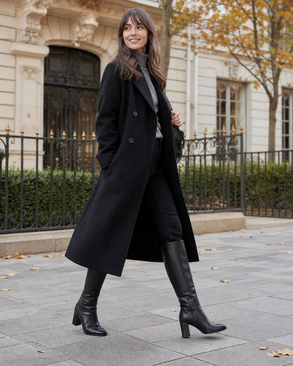 Women's black knee-high broad-heel boots, autumn city view.